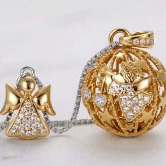 Foto da studio di due ciondoli Chiama Angeli 'Canto degli Angeli' in argento sterling e zirconi bianchi: a sinistra un piccolo angelo sagomato con pavé di zirconi, a destra la sfera sferica traforata con stelle in oro giallo e angelo centrale con zirconi.